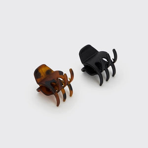 The KITSCH - ECO FRIENDLY MEDIUM CLAW CLIP, 2 PIECE SET features two medium-sized claw clips—one black and one tortoiseshell—secured on a cream “KITSCH” branded card labeled “Claw Clips.” Made from recycled materials, these eco-friendly clips are designed for comfortable all-day hold.