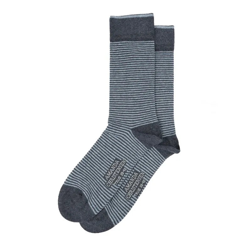 Pair of navy and gray AMANDA CHRISTENSEN - TRUE STRIPE MID-CALF SOCKS IN NAVY MELANGE with brand text printed on the soles.