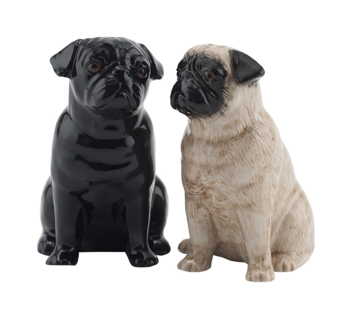 The QUAIL CERAMICS - PUG SALT AND PEPPER SET by QUAIL DESIGNS features two ceramic Pug figurines, one black and one light tan with a black face, sitting side by side against a plain white background.