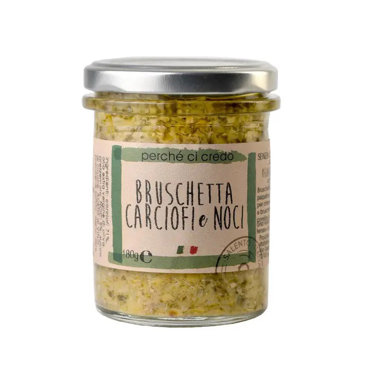 A glass jar with a silver lid containing "PERCHE CI CREDO - ARTICHOKE & WALNUT BRUSCHETTA," an exquisite Italian artichoke spread made by ZIA PIA IMPORTS. The light label features green and brown text, accented by the colors of the Italian flag. This delightful treat is perfect for fans of premium Italian foods.
