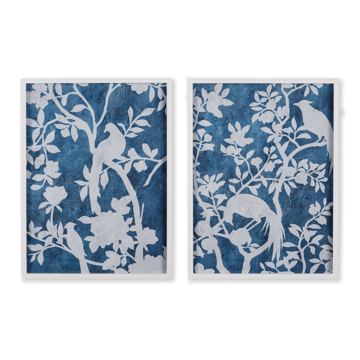 NAPA HOME AND GARDEN&#39;s &quot;Aviary Cyano&quot; prints showcase silhouettes of birds on tree branches in a textured blue backdrop, with intricately detailed white leaves and blossoms, offering a serene, nature-inspired aesthetic.