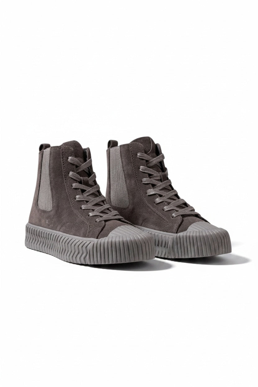 The DANIELLA LEHAVI - OSAKA HIGH TOP SNEAKER by DANIELLA LEHAVI features gray suede uppers and ribbed rubber soles, shown on a white pedestal against a plain light background. These stylish high-tops perfectly combine everyday comfort with modern style.