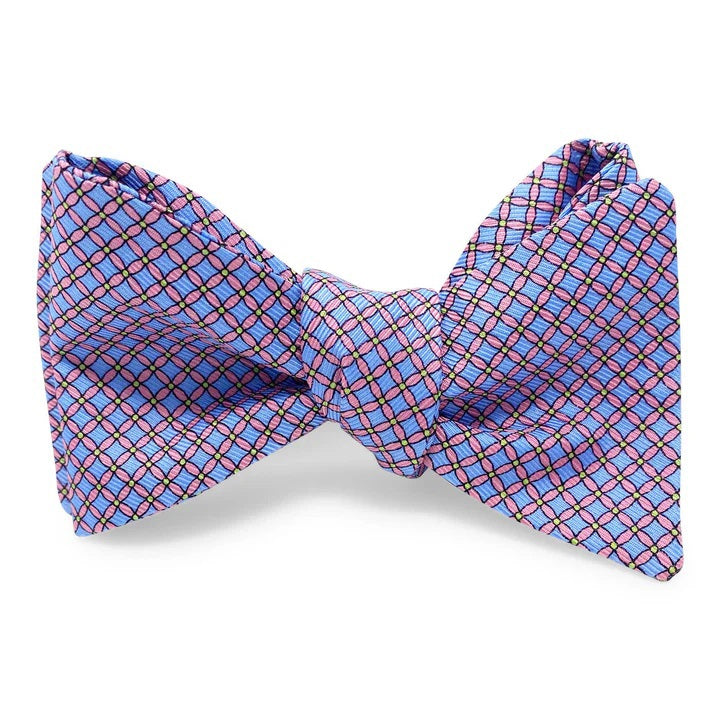 The PETER-BLAIR Cushions Silk Bow Tie in blue by BIRD DOG BAY features a self-tie, butterfly design with a red and black grid pattern. Made from printed silk, this untied bow tie shows adjustable neck sizing and pointed ends on a white background.