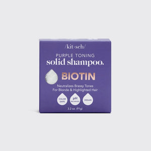 A KITSCH purple toning solid shampoo bar for blonde and highlighted hair, weighing 3.2 oz (91g), sits on its box labeled "KITSCH - Purple Toning Solid Shampoo Bar." It reduces brassiness and is color-safe, pH balanced, and vegan.