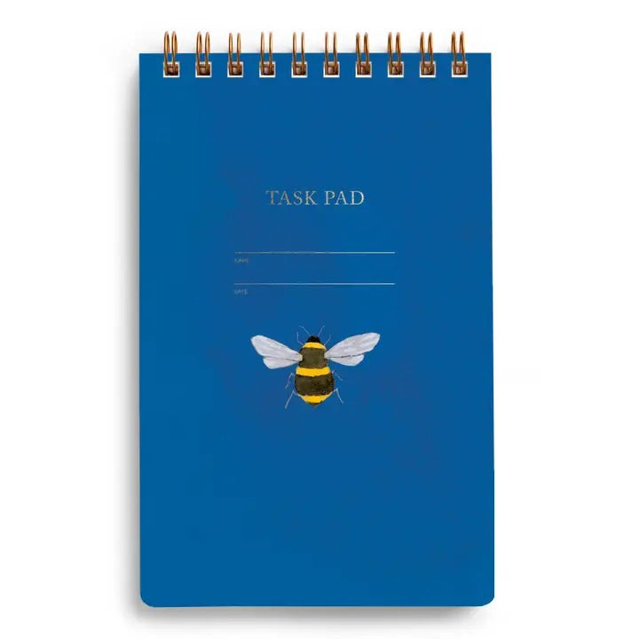 A close-up of the E. FRANCES - TASK PAD BEE by E. FRANCES PAPER shows a spiral-bound notebook with checkboxes on the left and light blue ruled lines, mostly blank, against a white background.