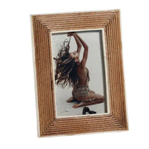 Showcase your cherished memories in the ZODAX Ribbed Mango Wood Frame with White Bone Border – 4x6. This elegant frame features an artisanal ribbed mango wood design accented by a refined white bone border, beautifully displaying a photograph of a person sitting on their knees with back exposed, arms raised, and long hair flowing against a light background.
