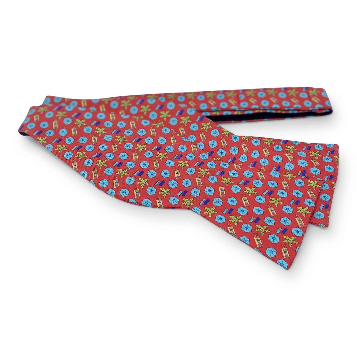 The BIRD DOG BAY PETER-BLAIR Sunscreen Silk Bow Tie in Red is laid flat on a white background, showcasing its handmade design with a repeating pattern of small blue and yellow floral-like shapes on luxurious red silk. The adjustable neck sizing guarantees a perfect fit for any occasion.