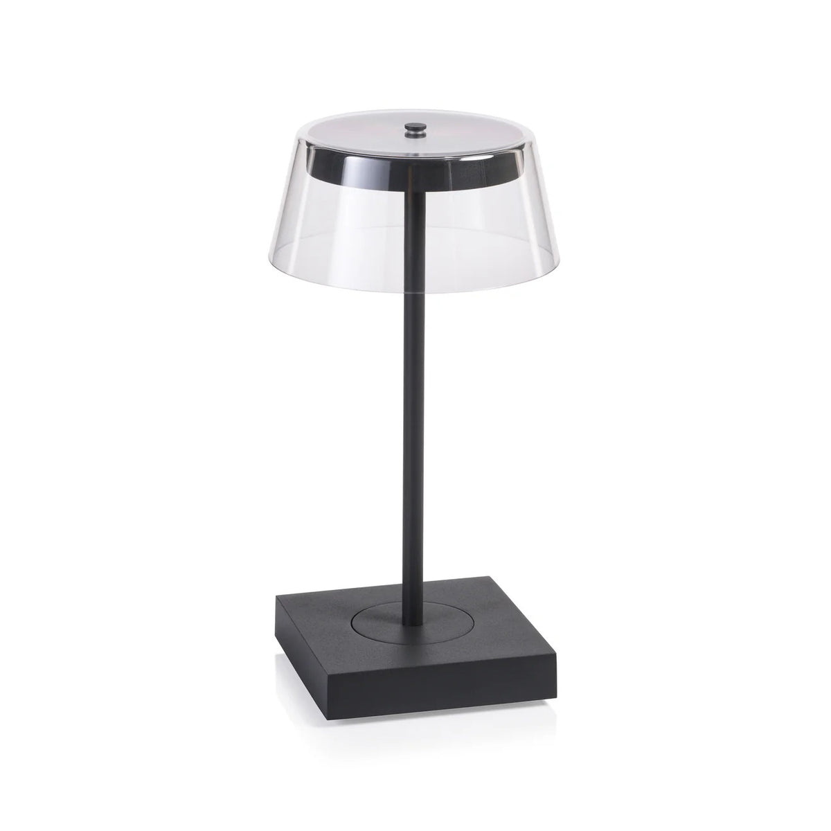 The SARDINIA RECHARGEABLE TABLE LIGHT by ZODAX, with a transparent shade and sleek dark base featuring adjustable brightness, is illuminated on a textured surface beside the book &quot;SHIRO TSUJIMURA: An Art of Living.