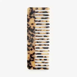 The MACHETE No. 2 Comb in Blonde Tortoise by MACHETE is a handcrafted Italian acetate comb with wide teeth, featuring a blonde tortoiseshell pattern of alternating dark brown and beige spots, shown vertically on a white background.