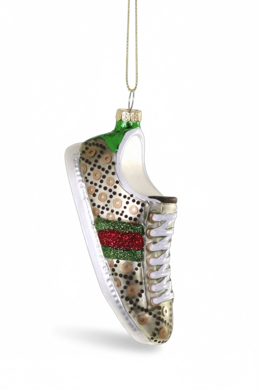The CODY FOSTER LUXE SNEAKER ORNAMENT features a glass sneaker shape with gold polka dots, red and green glitter stripes, white laces, a gold cap with loop, and measures 4" high by 1.5" long, shown against a white background.