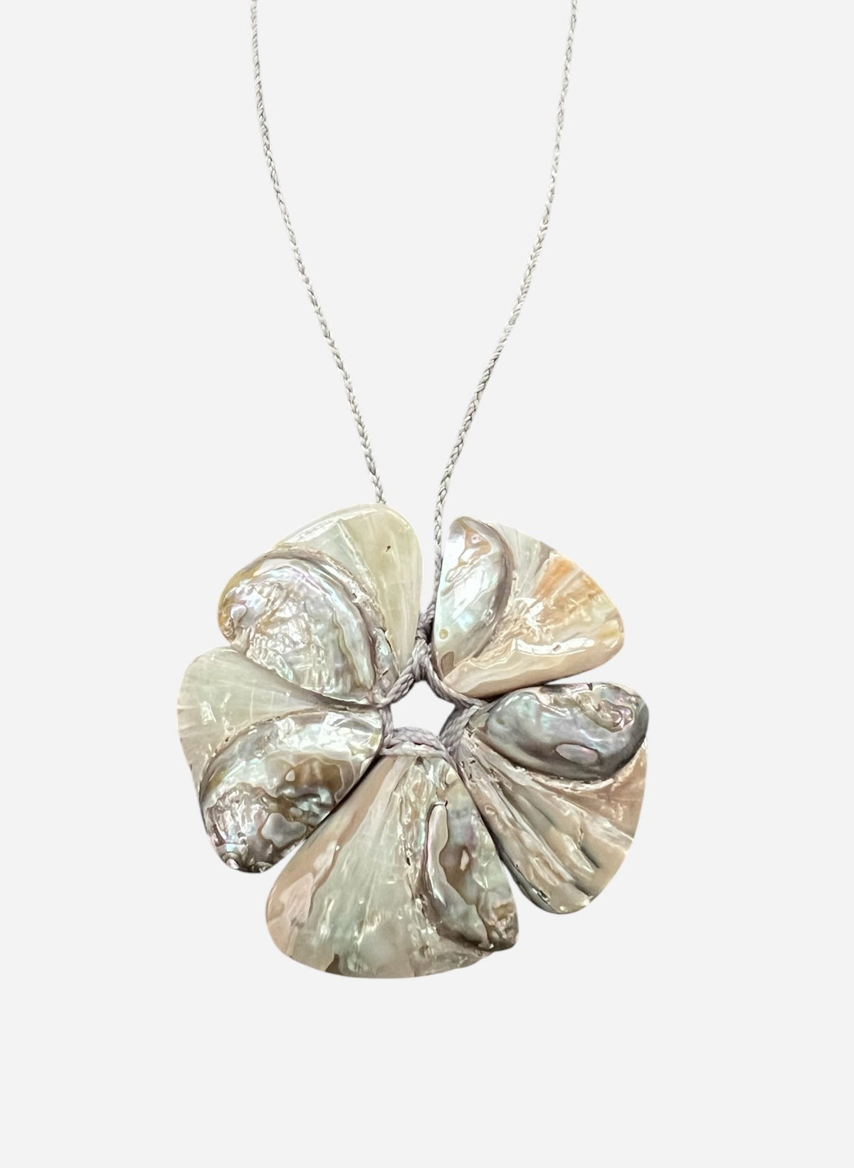 The ANN LIGHTFOOT Large Abalone Flower Necklace features a pendant with iridescent mother-of-pearl petals in silvery and beige on a silver chain, offering a glossy, elegant look that ensures you stand out stylishly.
