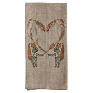 SQUIRRELS WITH WHEAT HEART LINEN TEA TOWEL by CORAL & TUSK featuring two embroidered squirrels holding stalks of wheat that form a heart shape above them.