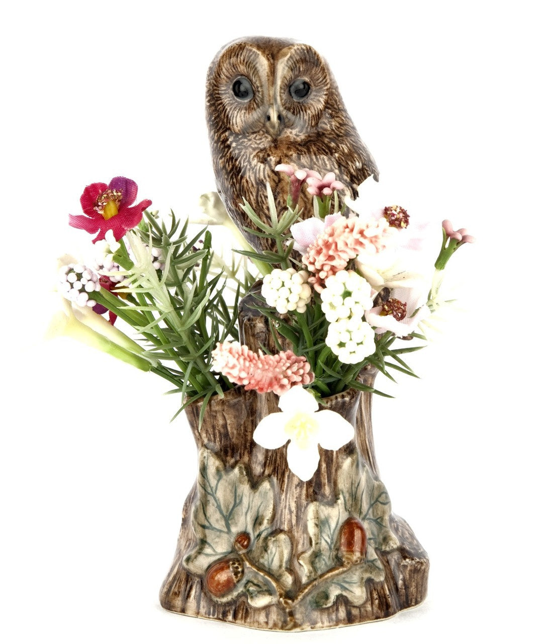 The QUAIL CERAMICS Tawny Owl Bud Vase by QUAIL DESIGNS features a hand-painted stoneware owl perched on a textured tree stump with green leaves and brown acorns at the base, set against a white background.