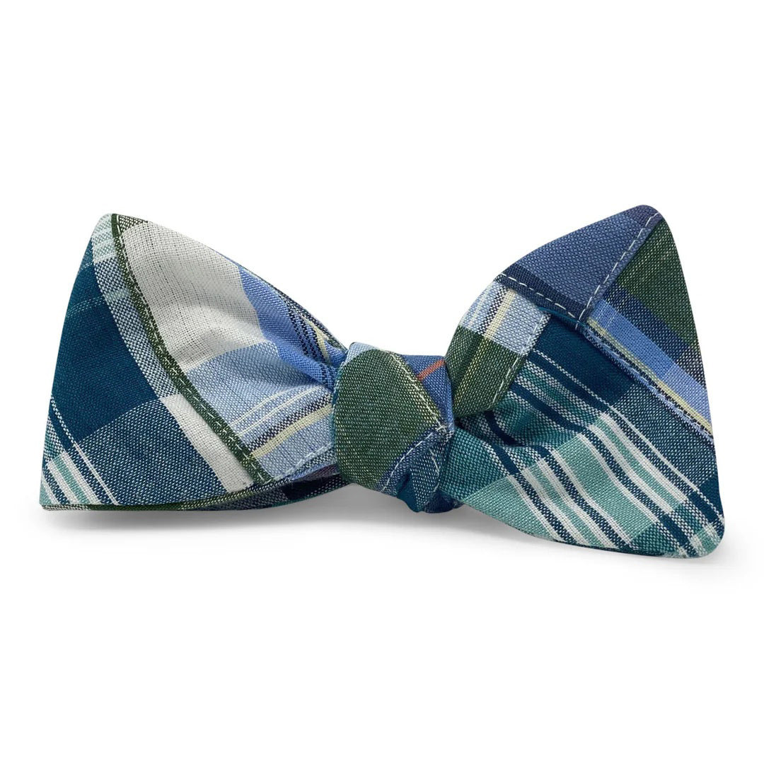 The COLLARED GREENS - CLAYMONT CAROLINA COTTON BOW TIE by BIRD DOG BAY showcases handmade blue, green, and white intersecting lines and patterns, presented on a white background.