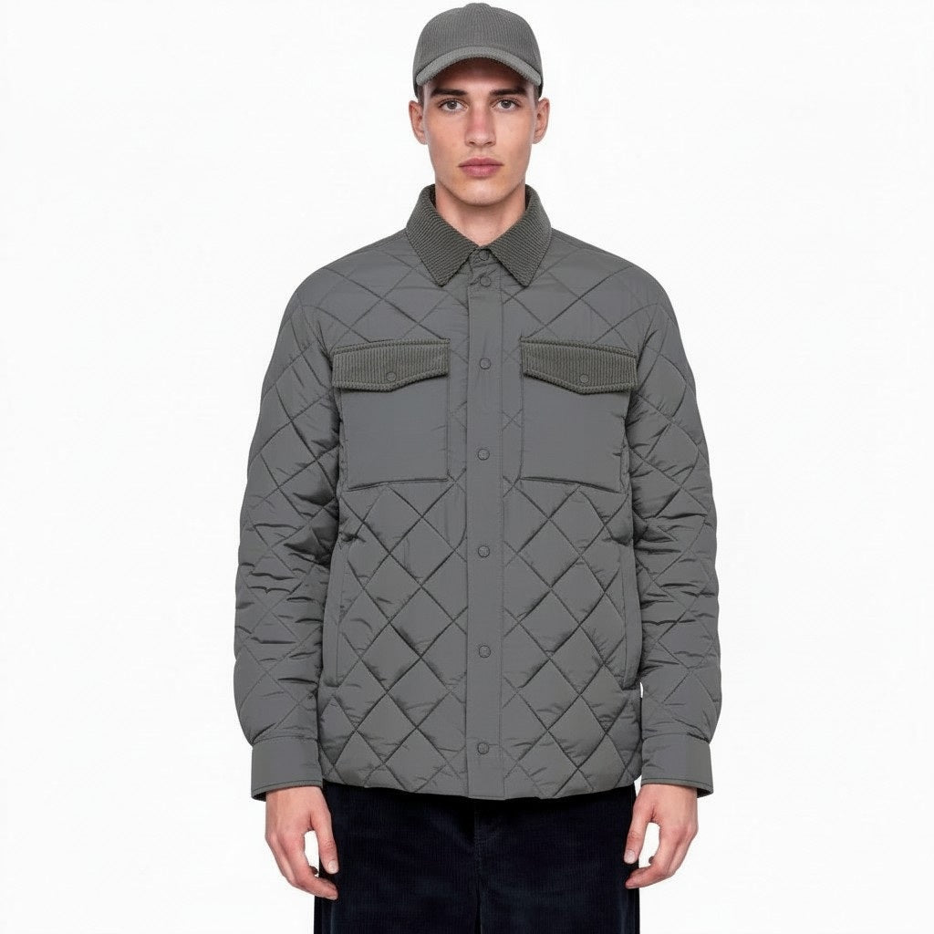 A person stands facing forward against a plain white background, wearing the SAVE THE DUCK - FIRMIN Puffer Jacket in gunmetal grey, which features a diamond quilted design, two front pockets, and animal-free insulation, paired with a matching grey cap.