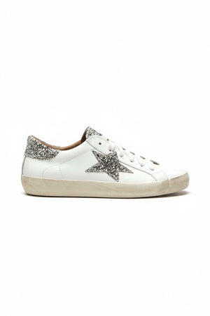 The MICHELE LOPRIORE - GEMMA SNEAKER WITH SILVER STAR by MICHELE LOPRIORE showcases smooth leather construction accented with a sparkling silver star on the side and a coordinating glittery heel tab. Set against a clean, light background, its ultra-light rubber sole features an intentionally worn finish that enhances its laid-back appeal.