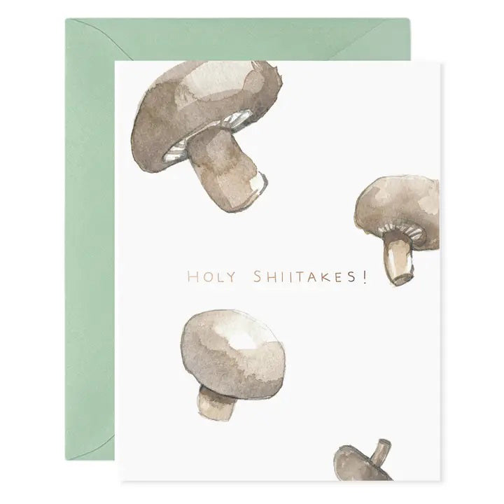 The E. FRANCES - HOLY SHIITAKES greeting card by E. FRANCES PAPER features a small mushroom illustration near the bottom center, &quot;E. Frances&quot; text below it, and comes with a pale green envelope. Proudly made in the USA.
