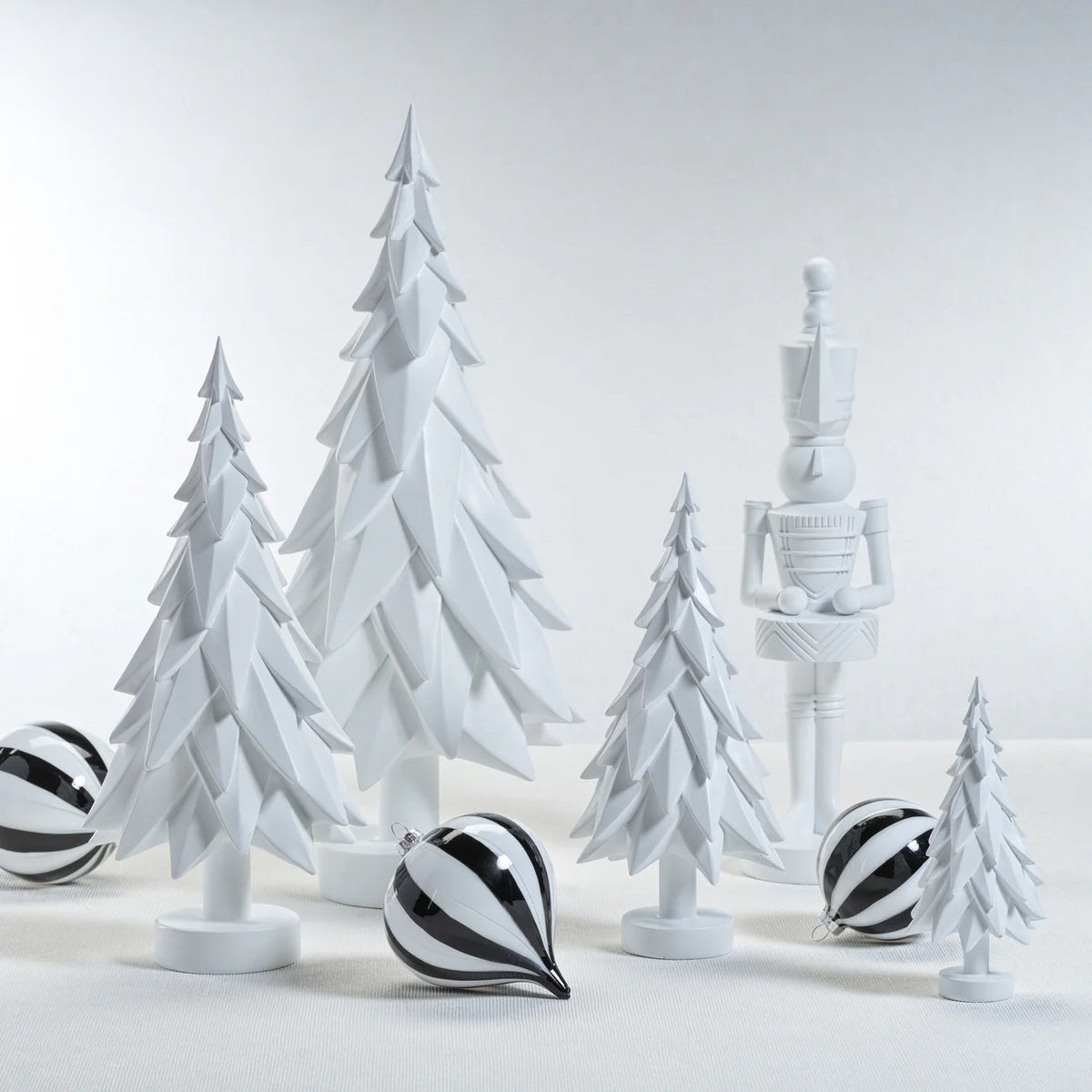 The ZODAX MATTE WHITE DECORATIVE TREE - SMALL is a minimalist resin sculpture featuring layered, geometric branches and a round base, showcased against a plain white background.