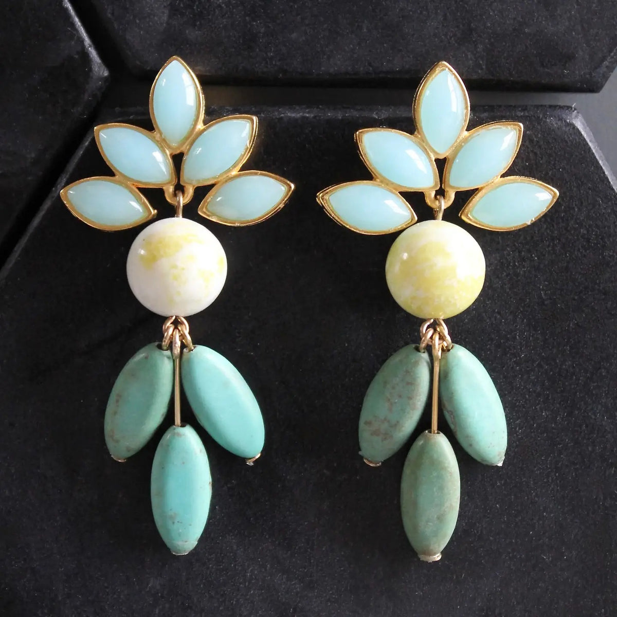 The DAVID AUBREY Vintage Glass and Turquoise Earrings showcase decorative marquise glass with gold and light blue leaf shapes, a central round white-and-yellow bead, and three elongated turquoise beads that dangle below.