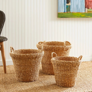 The NAPA HOME AND GARDEN Seagrass Tapered Basket with Handles and Cuff, Large, is shown from above, highlighting its natural seagrass texture and expert craftsmanship on a matching surface.