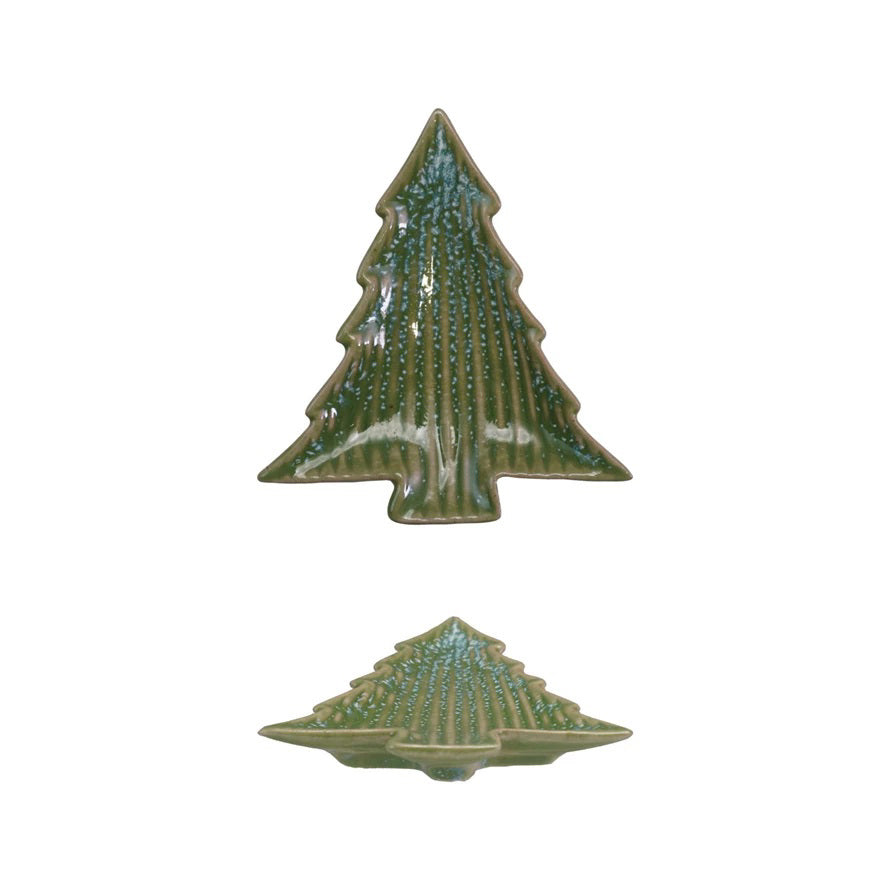 A CREATIVE COOP STONEWARE RIBBED TREE SHAPED PLATE, featuring a Christmas tree cookie with green and white icing and scattered brown sprinkles, rests on a white surface.