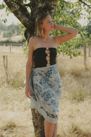 Crafted from soft cotton voile for an elegant yet lightweight feel, the MAISON LECOMTE - BANDANA DINARD SARONG by MAISON LECOMTE FLAMENT features a rectangular silhouette in light blue and white. Detailed with intricate blue floral and paisley patterns and decorative borders reminiscent of a traditional Persian rug, this piece is both stylish and comfortable.