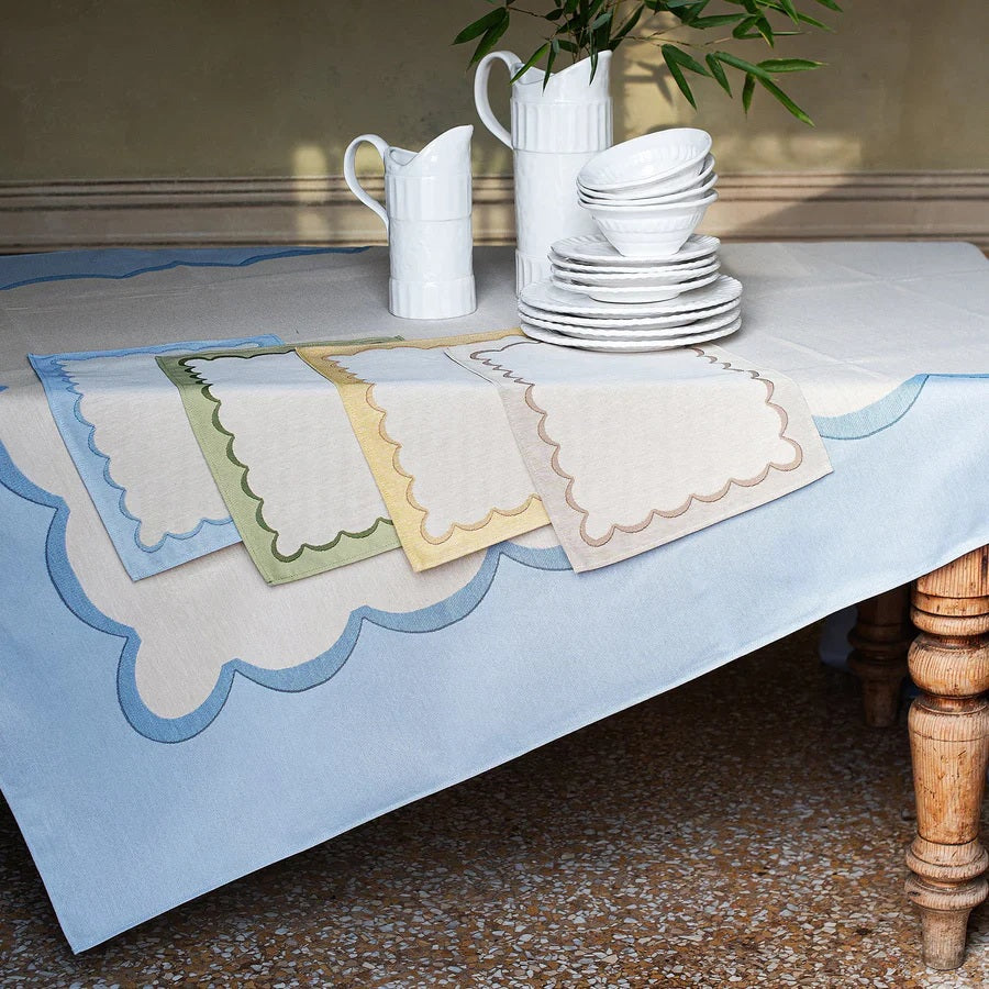The VIETRI Tavola Scalloped Tablecloth in green features a beige cotton-polyester blend with a light green border and a distinctive scalloped dark green edge.
