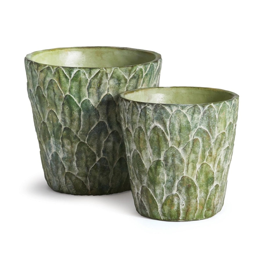 The NAPA HOME AND GARDEN - FELDBURG POT, SMALL features a green ceramic finish with a textured surface that resembles overlapping leaves or scales for an artichoke-like look. The plant pot is shown against a plain white background.