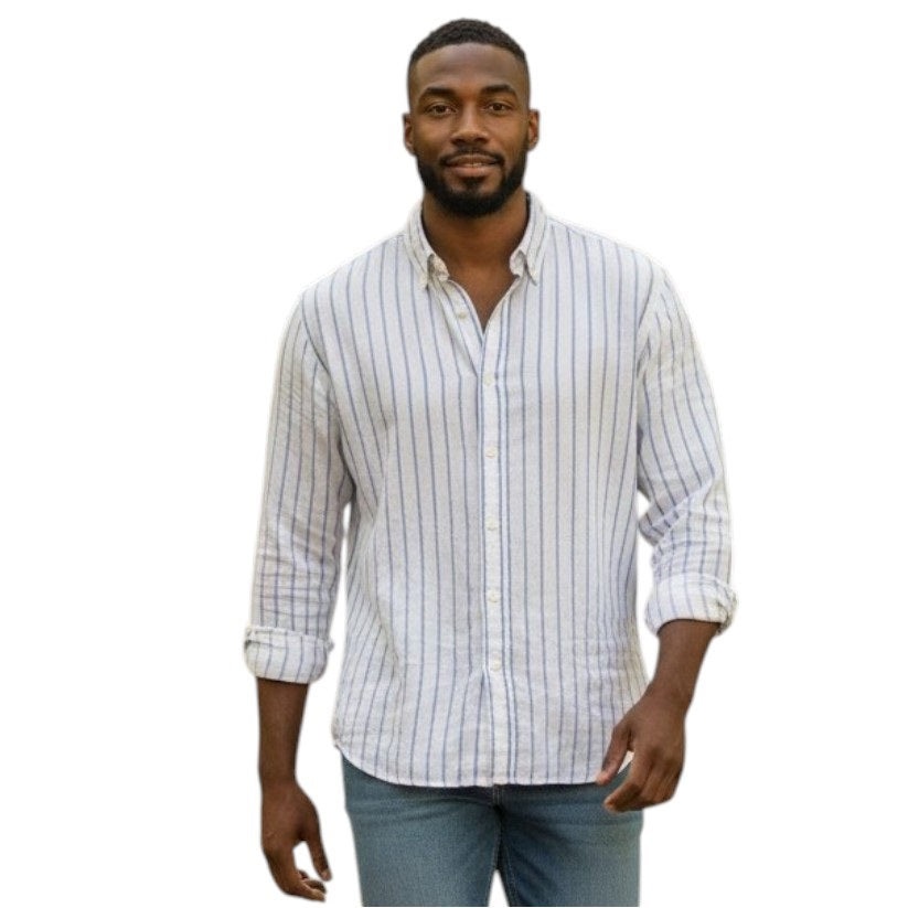 A man stands facing forward and smiling against a white background, wearing FRANK & EILEEN's FINBAR Men's Button Up Shirt in white with turquoise stripes (washed linen) and blue jeans.