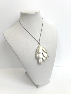 The ANN LIGHTFOOT - CHAMBERED NAUTILUS SHELL SPRAY NECKLACE by ANN LIGHTFOOT is showcased on a white jewelry bust against a plain white background. Reminiscent of an elegant spray necklace, this piece features overlapping metallic chambered nautilus shell pendants suspended from an adjustable sleek black nylon cord.