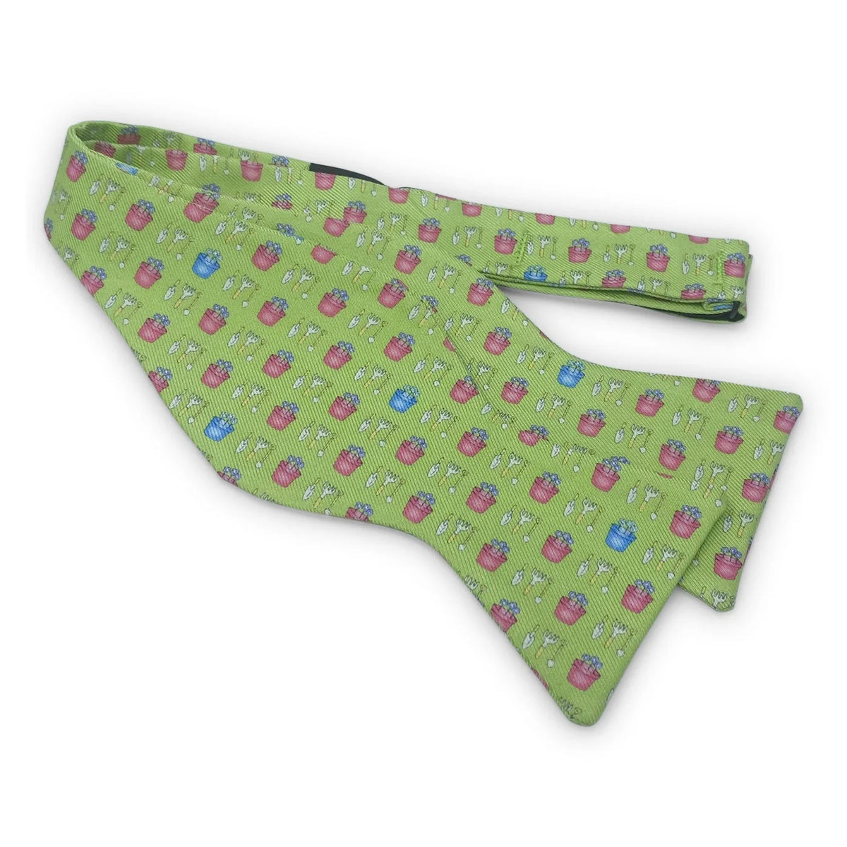 Introducing the BIRD DOG BAY PETER-BLAIR Garden Silk Bow Tie in Green, featuring a charming print of small pink and blue flower pots and white gardening tools. Handmade in North Carolina, this bow tie offers adjustable neck sizing for a perfect fit.