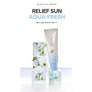 A tube of KOSMIC KBEAUTY SKINCARE BEAUTY OF JOSEON - RELIEF SUN SUNSCREEN, AQUA FRESH SPF 50+ is positioned on and next to four ice cubes containing embedded flowers, set against a crisp white background.
