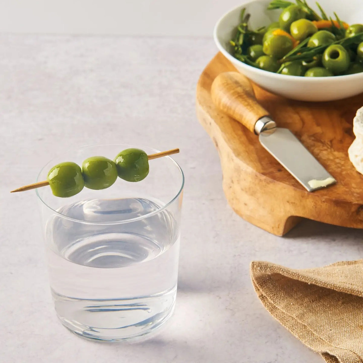 A glass jar of DIVINA - ORGANIC PITTED CASTELVETRANO OLIVES with a black lid features a green front label with white text, displaying the USDA Organic certification. Plump Sicilian olives are clearly visible inside.