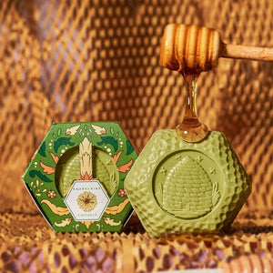 Hexagonal box of BAUDELAIRE - CALENDULA HONEY SOAP 3.5 OZ, featuring green floral packaging with a central clear window displaying the triple-milled moisturizing bar and a floral design label on top, by BAUDELAIRE.