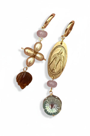 SANDRINE FRANCE STUDIO - HOLLY EARRINGS: Handmade in NYC, these mismatched gold-plated brass earrings feature unique designs—one earring showcases pearls, a brown seashell bead, and a pink bead; the other is adorned with an engraved oval gold charm, a pink bead, and a round faceted clear bead with an intricate floral motif.