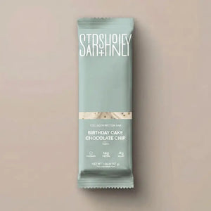 A wrapped STARS+HONEY - BIRTHDAY CAKE CHOCOLATE CHIP bar rests on a beige surface. The light blue packaging, branded with the STARS+HONEY logo and white text, displays nutrition details and hints at the irresistible flavors of vanilla yellowcake and natural sprinkles inside.