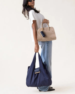 The KEOTE - KEYCHAIN TOTE IN NAVY by KEOTE is shown flat with its matching rectangular case and keychain above it, combining easy storage and style—a perfect purse accessory set against a plain, light background.