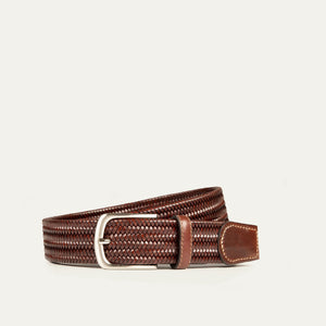 The WILL LEATHER GOODS - STRETCH BELT features a green, purple, and black braided design with full-grain leather accents by the silver buckle and tip, shown on a plain light background. Brand: WILL LEATHER GOODS.
