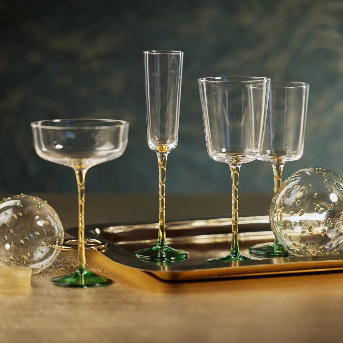 VICENZA GREEN AND AMBER RED WINE GLASS featuring a 9-inch clear bowl, a green base, and a 3.5-inch patterned amber stem.