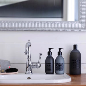 A frosted grey pump bottle of COMPAGNIE DE PROVENCE's Savon Liquide De Marseille Cashmere Soap by CIE LUXE BRANDS features a black dispenser and contains 300 ml (10 fl. oz.) of soap infused with luxurious botanical oils.