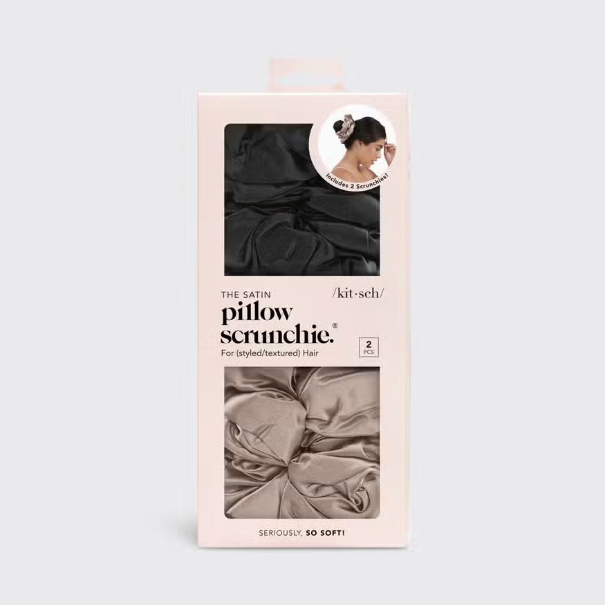 Two satin scrunchies are stacked against a light gray background. These KITSCH - SATIN SLEEP PILLOW SCRUNCHIES, in black and beige, offer a smooth, shiny texture ideal for frizz-free styling and breakage prevention.