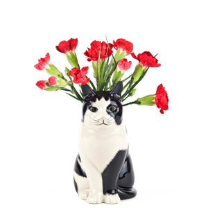 The QUAIL DESIGNS QUAIL CERAMICS - BARNEY CAT FLOWER VASE SMALL is a glossy black and white hand-painted stoneware vase, shaped like a cat sitting upright and facing left, shown against a plain white background.