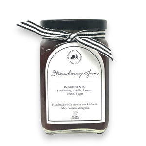 Introducing the FEARRINGTON HOUSEMADE STRAWBERRY JAM from the FEARRINGTON SIGNATURE COLLECTION, this jar of delicious strawberry jam is adorned with a charming black and white striped ribbon tied around the lid. Perfect as a hostess gift, its label lists wholesome ingredients such as strawberry, vanilla, lemon, pectin, and sugar. This handmade treat may contain allergens and is a delightful choice for breakfast jam enthusiasts.