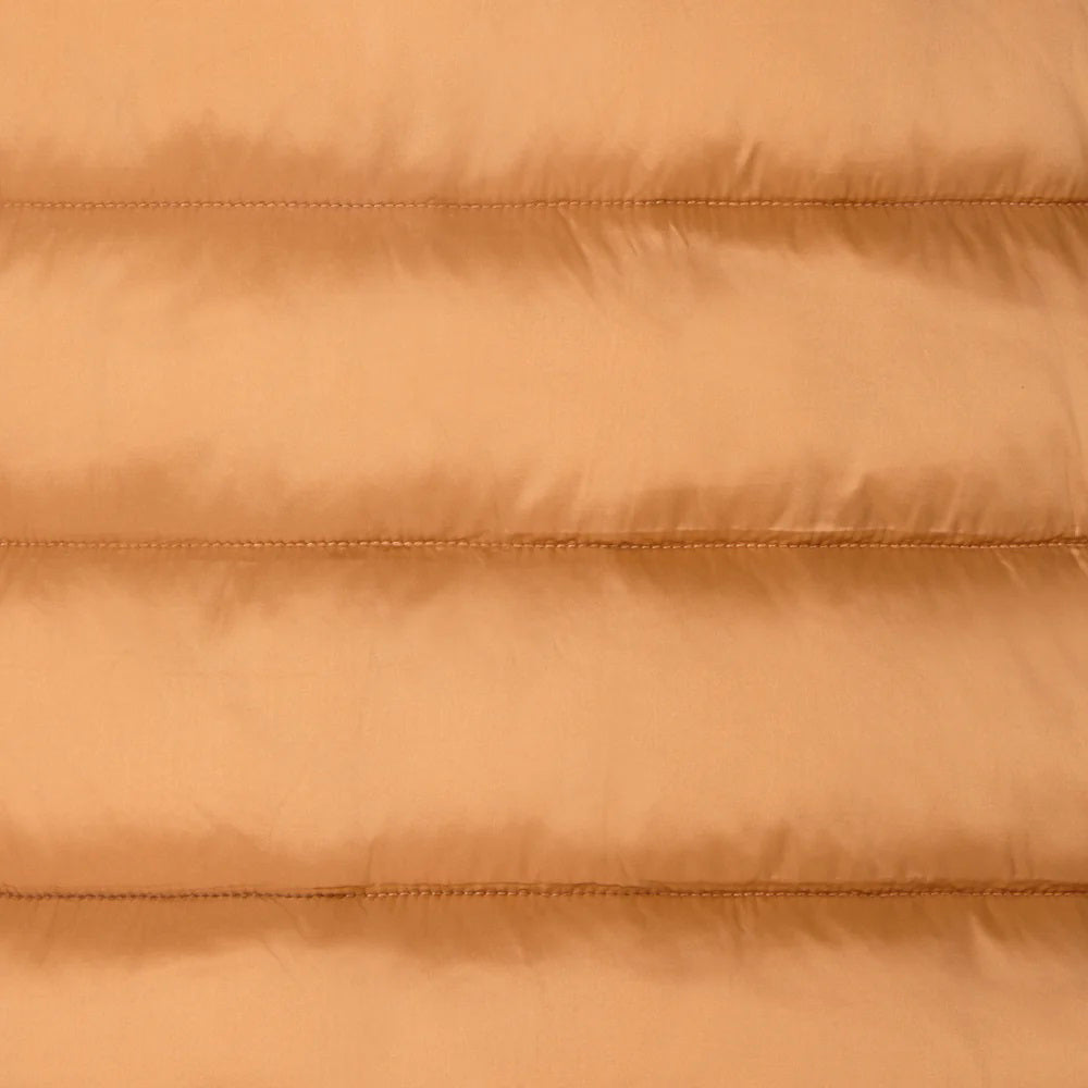 A person stands facing away in the SAVE THE DUCK - ELSIE PUFFER JACKET by SAVE THE DUCK, paired with loose green pants and tan boots against a plain light background.