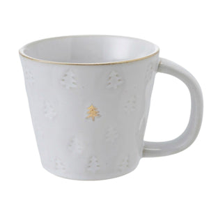 Creative Co-op DEBOSSED STONEWARE MUG WITH GOLD RIM AND TREE, matching creamer, and tree-shaped plate, all featuring a debossed tree pattern and gold rims, displayed with Christmas ornaments and small cookies as festive holiday drinkware.