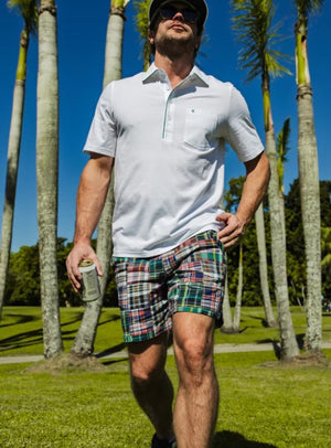 The CRIQUET Cruiser Shorts in Navy Madras feature a colorful plaid patchwork, elastic waistband with white drawstring, and are crafted from 100% cotton for comfort and style.
