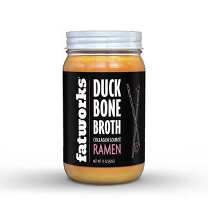 A jar of FATWORKS - RAMEN DUCK BONE BROTH is shown. The clear jar with a white lid reveals golden yellow contents. Labeled "FATWORKS," it highlights being protein-packed and a rich collagen source, perfect for keto diets. Net weight is 15 oz (425g).