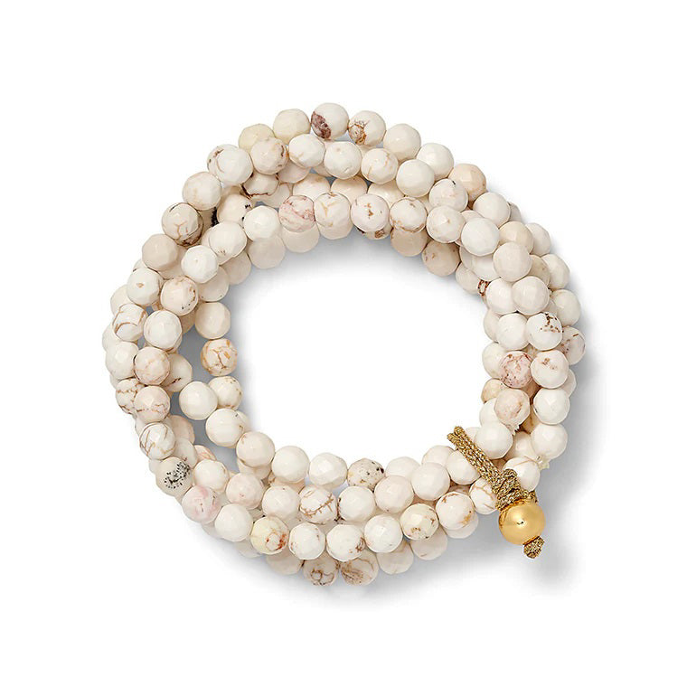 The Sally Bracelet by CC & CO BY CATHERINE CANINO features stretchy natural white reconstructed turquoise beads with subtle marbling and a gold clasp, plus a gold accent bead, combining versatile elegance.