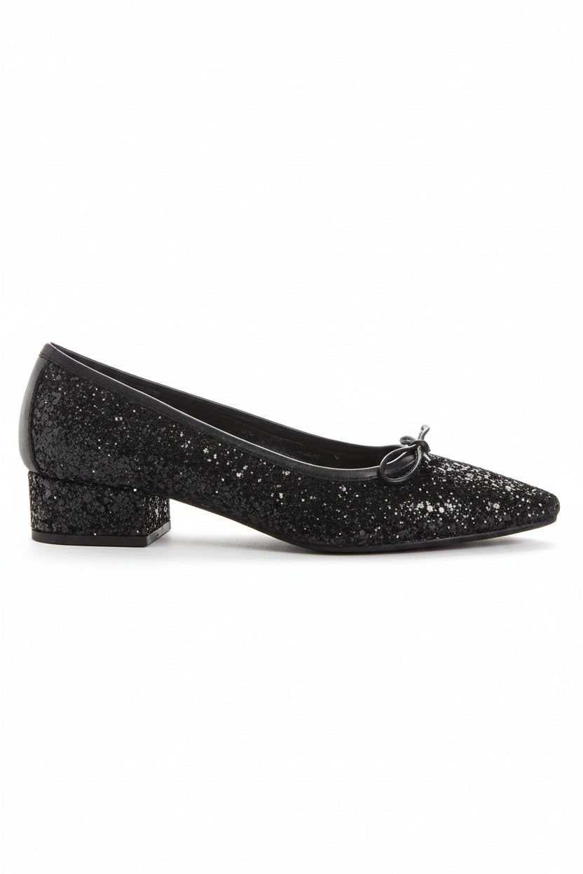 A single REQINS - FETICHE GLITTER HEELED BALLERINA shoe, black and covered in glitter, viewed from above with a small bow on the toe and "REQINS" on the insole—perfect elegant party shoes.