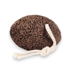 The SMILE BOUTIQUES NATURAL PUMICE STONE FOOT SCRUBBER features a brown, rough, and porous surface ideal for foot care and effective callus removal. It comes with a white rope loop for convenient hanging, as shown against a white background.